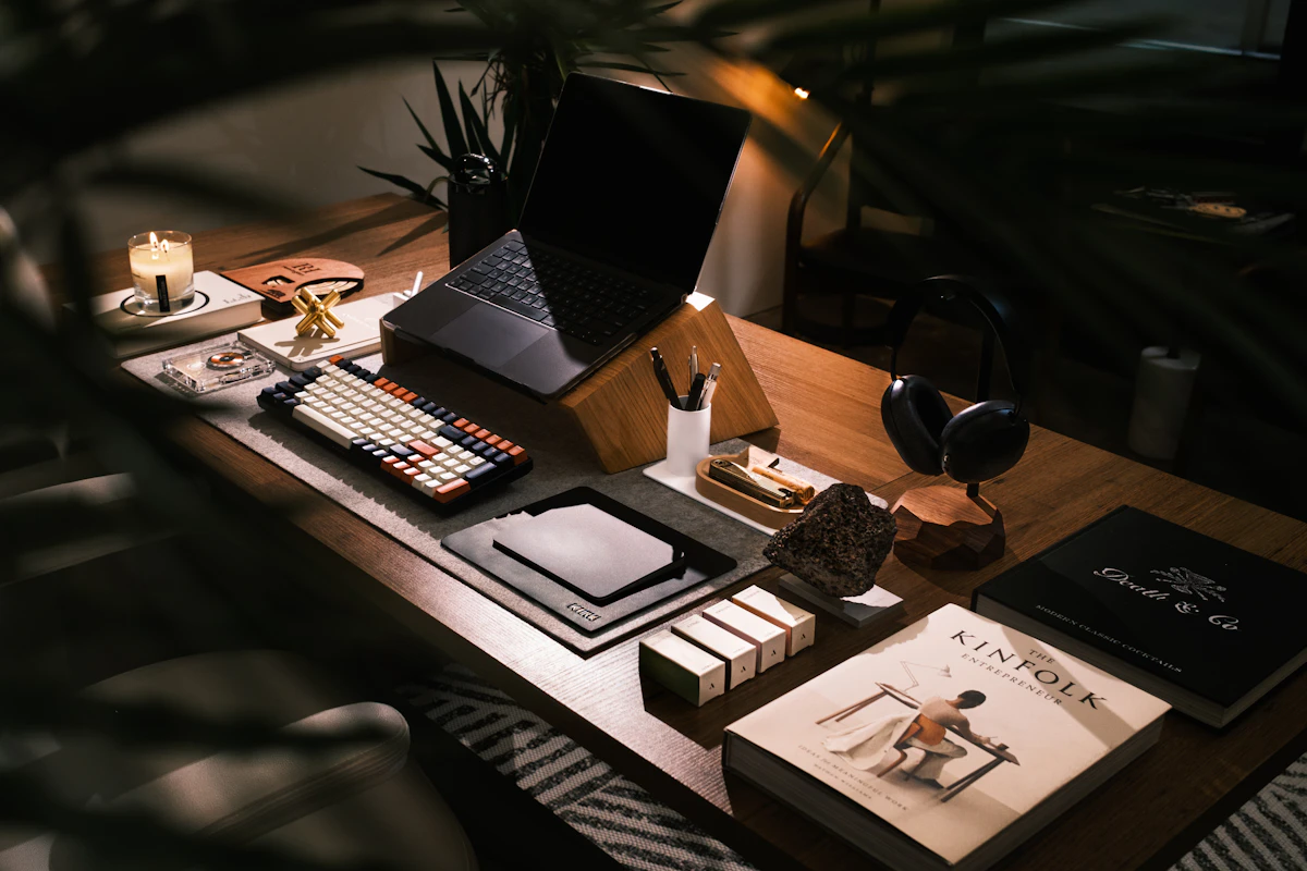 Foto ilustrasi ruang kerja dengan laptop, buku, dan perlengkapan meja.